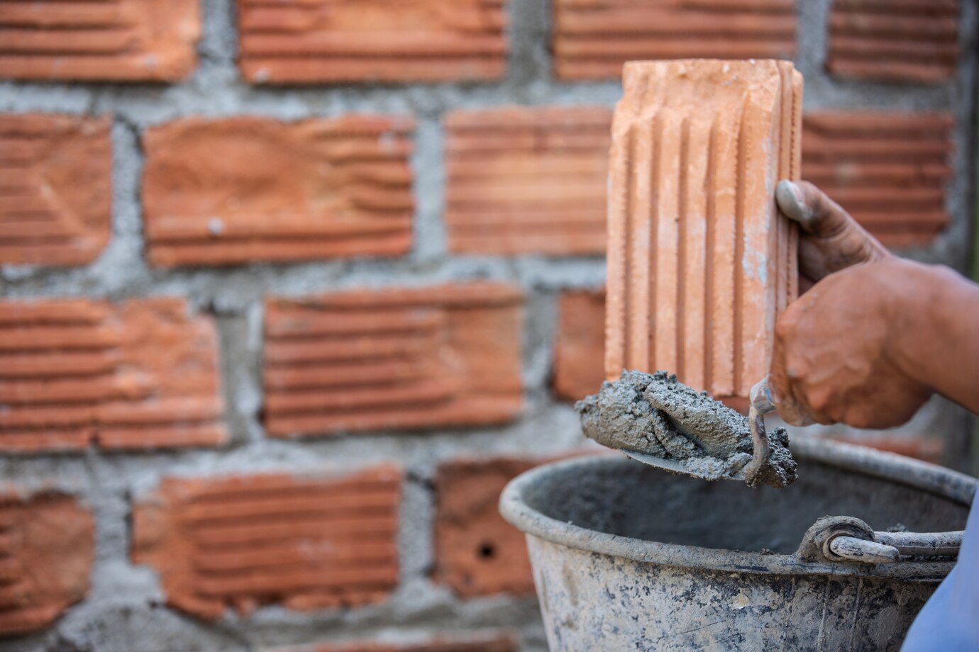 Masonry worker on the outside wall with a trowel knife.<br />
